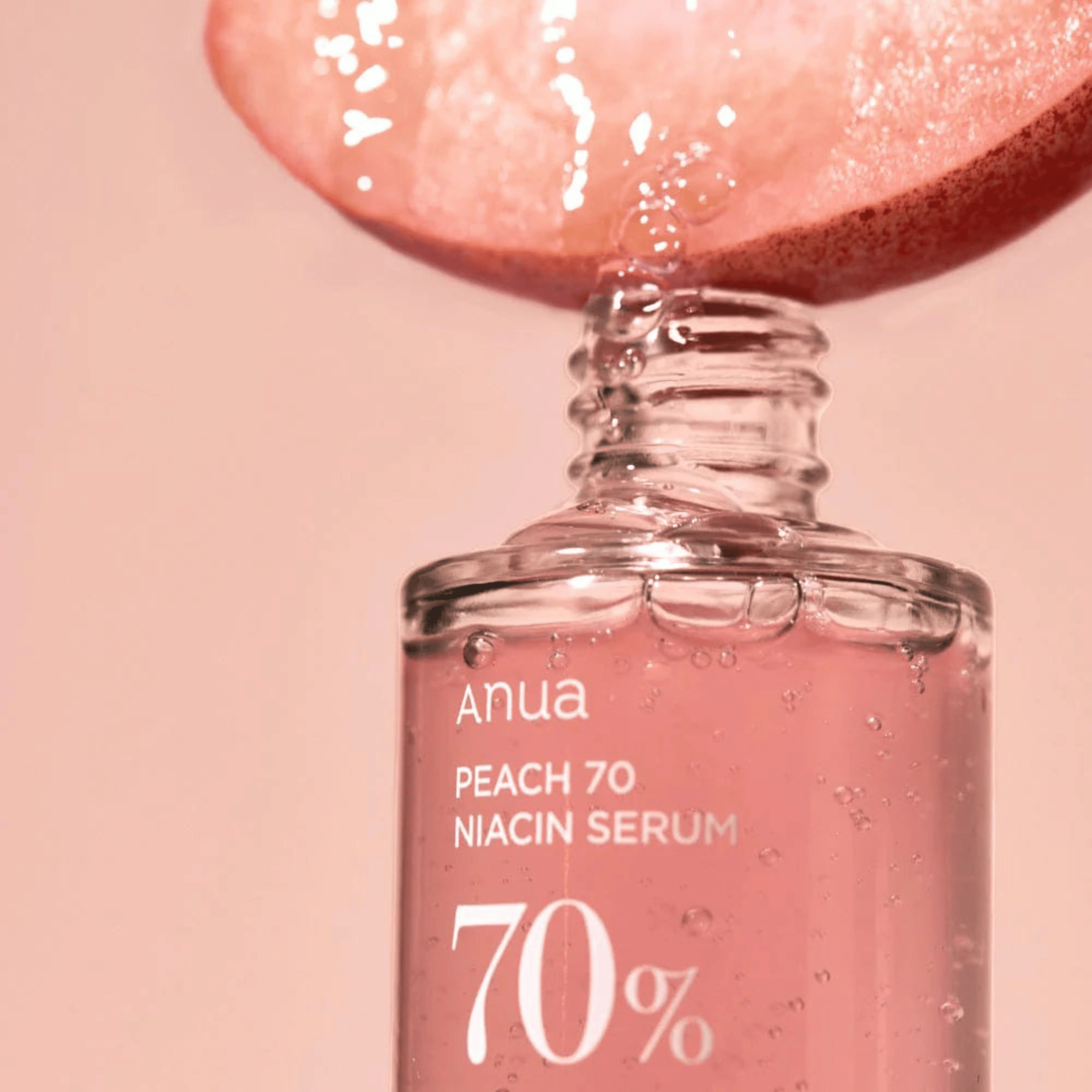 Pfirsichextrakt tropft in das Anua Peach 70% Niacin Serum