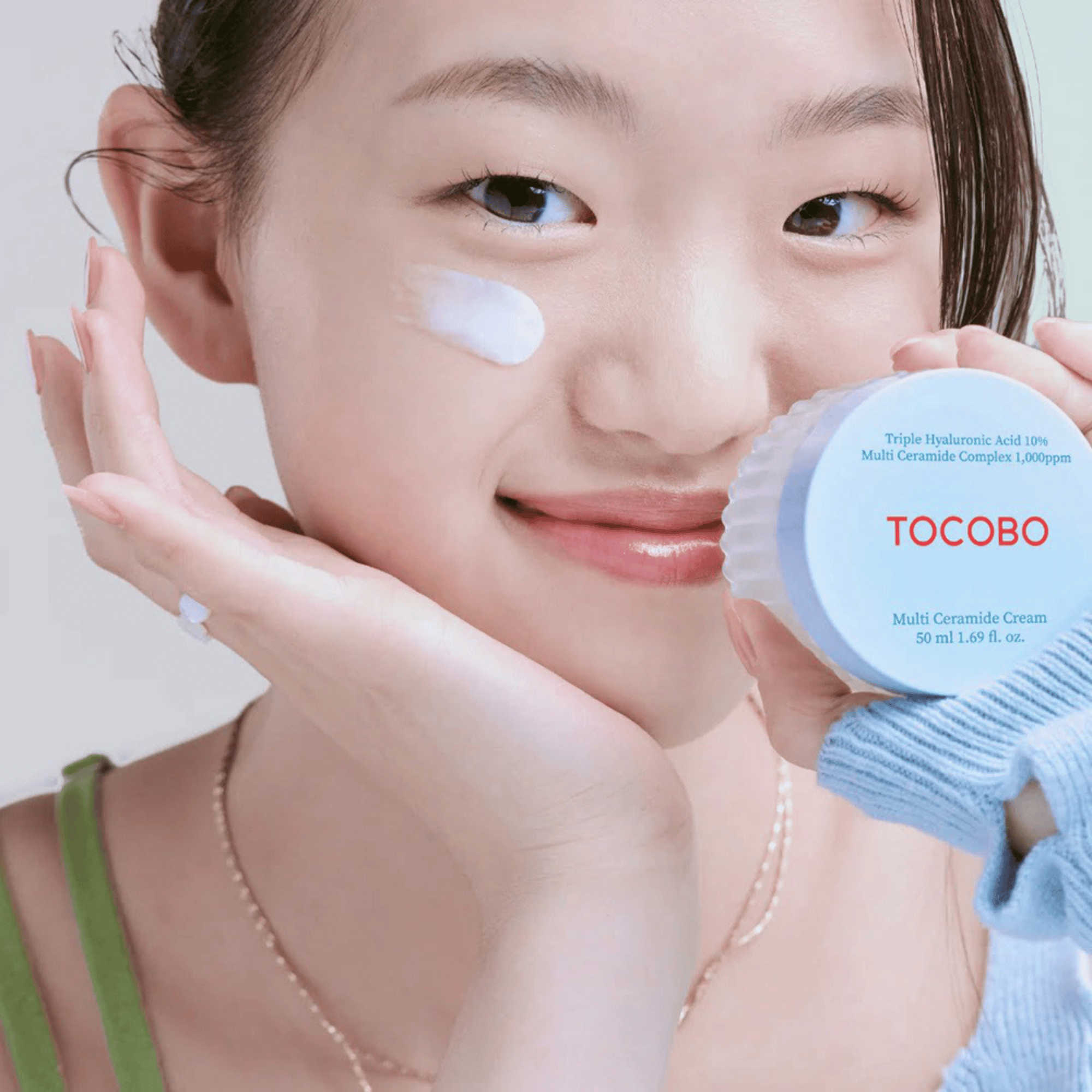 Model trägt Tocobo Multi Ceramide Cream im Gesicht und hält den Tiegel in der Hand korean skincare Anwendung