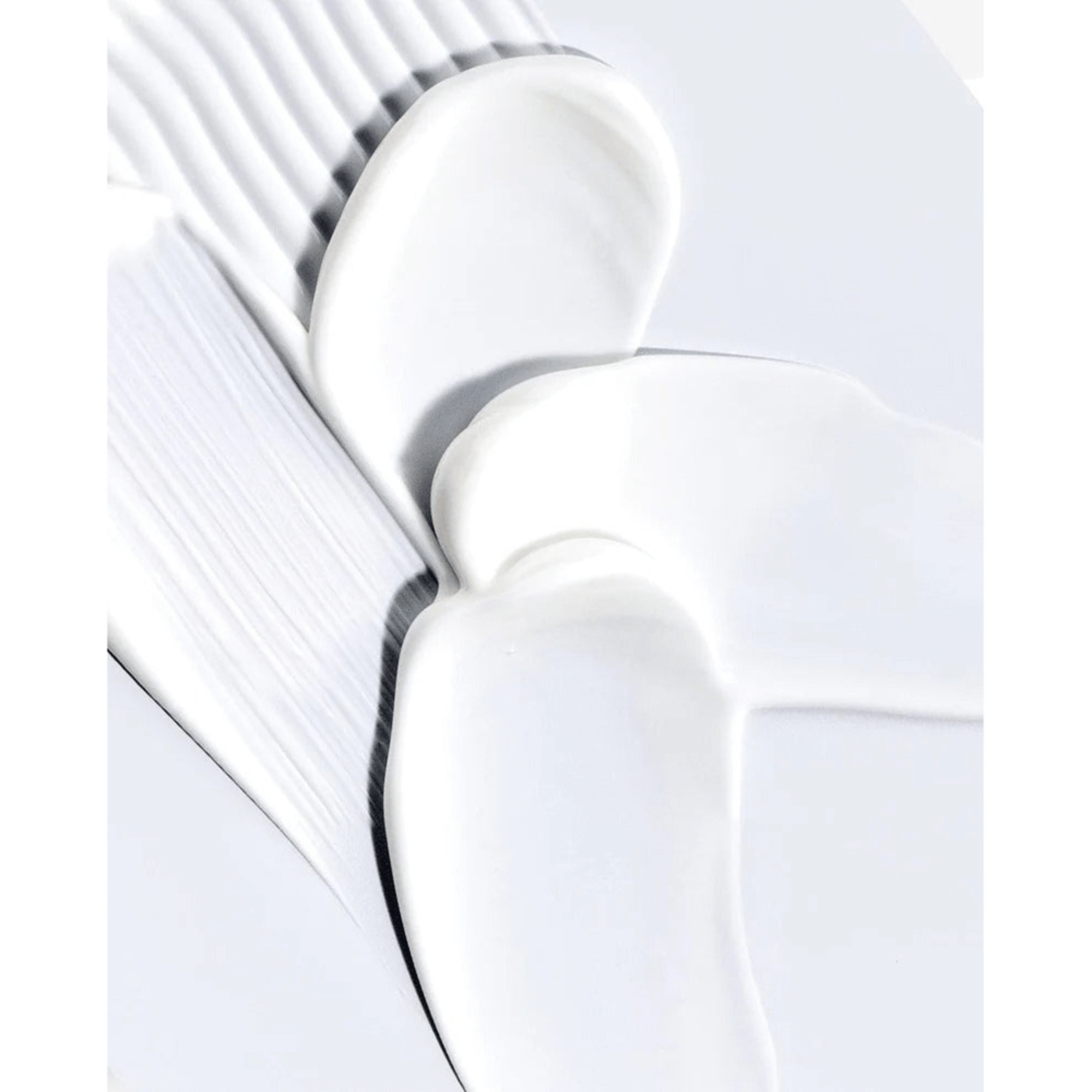 Anua Heartleaf 70% Daily Lotion 200ml wird in überlappenden Strichen auf eine flache, helle Oberfläche aufgetragen und enthüllt ihre cremige Textur und ihr glänzendes Finish.