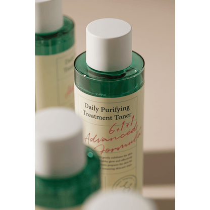 Nahaufnahme des Axis-Y Daily Purifying Treatment Toners, umgeben von mehreren Flaschen auf beige Hintergrund