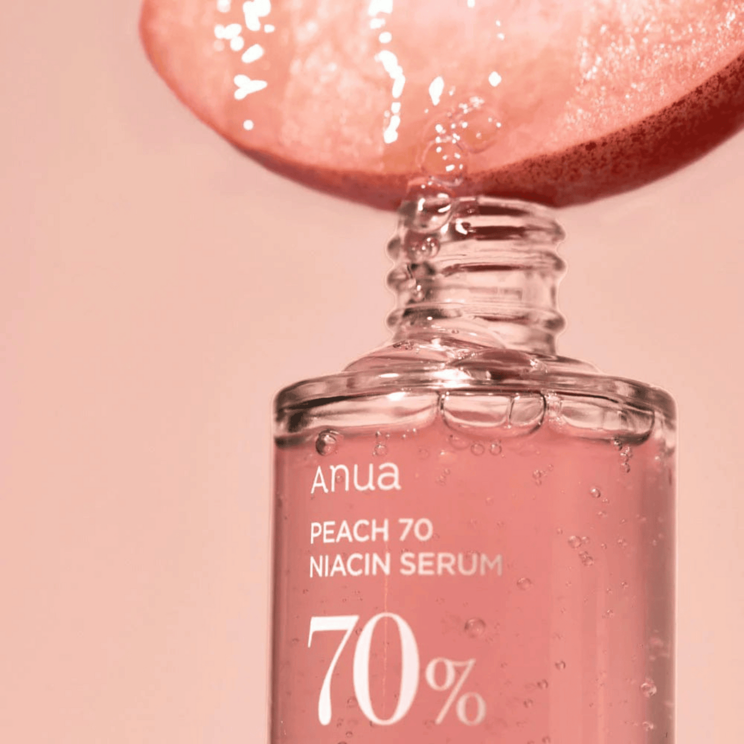 Pfirsichextrakt tropft in das Anua Peach 70% Niacin Serum 