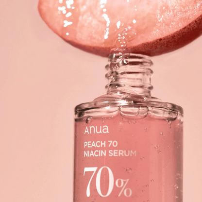 Pfirsichextrakt tropft in das Anua Peach 70% Niacin Serum 