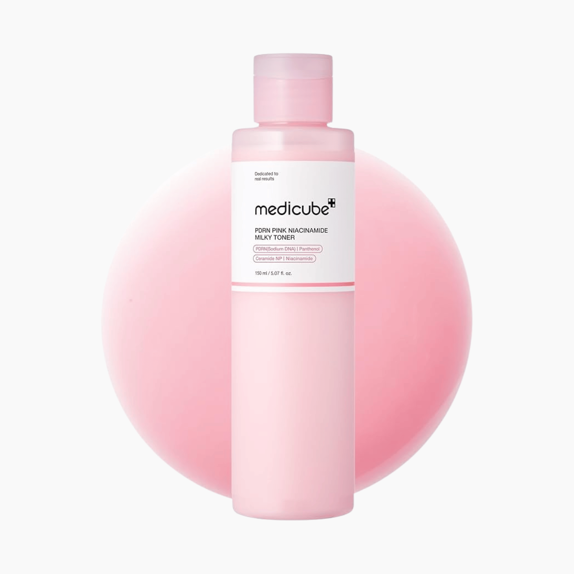 Eine Flasche Medicube PDRN Pink Niacinamid Milky Toner 150ml wird vor einem blassrosa runden Hintergrund dargestellt.