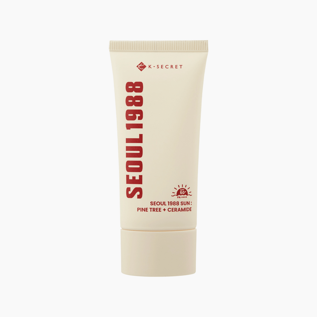 Eine beigefarbene Tube von K-Secret SEOUL 1988 Sun Pine Tree + Ceramide SPF 50+ PA++++ (50ml) steht aufrecht auf einem weißen Hintergrund.