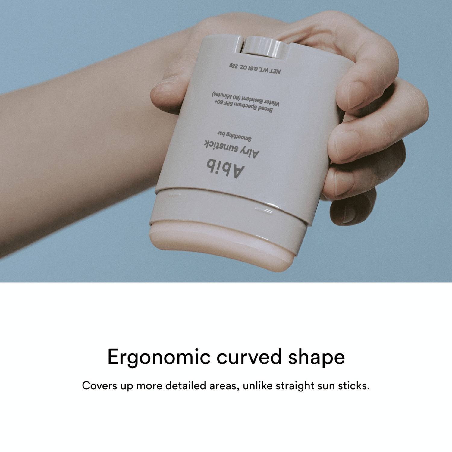 Eine Hand hält einen beigefarbenen, ergonomischen Abib Airy Sunstick Smoothing Bar 23g, dessen Design und Deckkraft unten angezeigt wird.