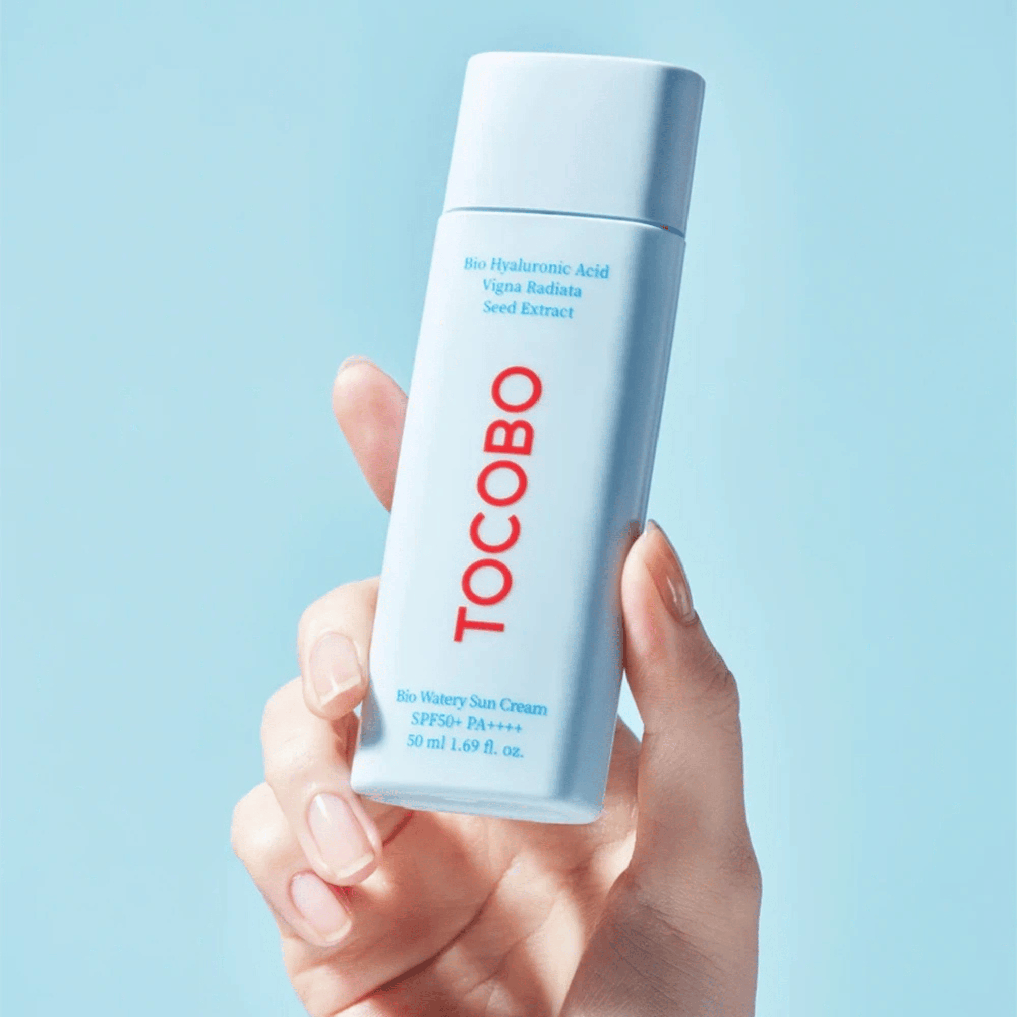 Die Tocobo Bio Watery Sun Cream wird in einer Hand präsentiert, minimalistisches Design in Hellblau SPF50+ PA++++