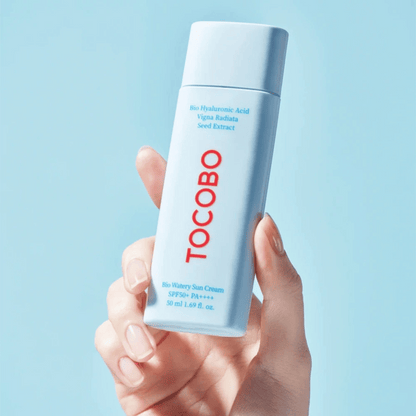Die Tocobo Bio Watery Sun Cream wird in einer Hand präsentiert, minimalistisches Design in Hellblau SPF50+ PA++++