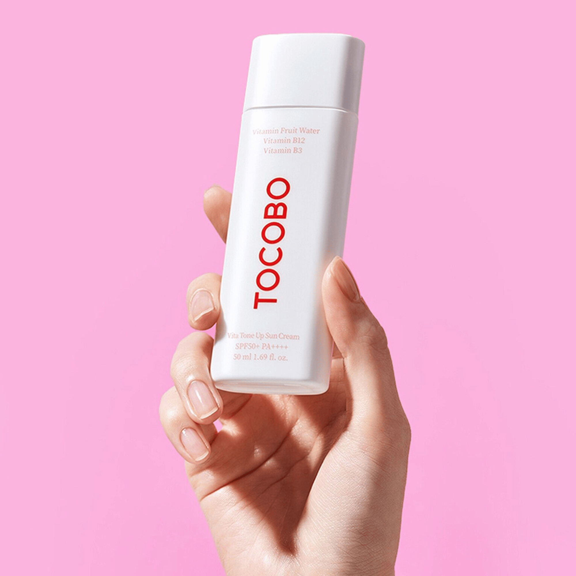 Sonnenschutz von Tocobo in heller Hand vor pinkem Hintergrund leichte, vitaminreiche Pflege mit SPF50+