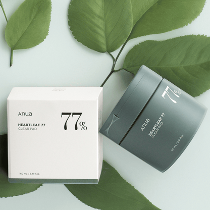 Anua Heartleaf Clear Pad mit Umverpackung auf hellblauem Hintergrund mit Blättern – sanft zur Haut, ideal für K-Beauty Fans