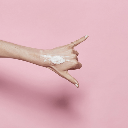 Textur des BANILA CO Clean It Zero Cleansing Balm Original auf Handrücken aufgetragen, vor rosa Hintergrund