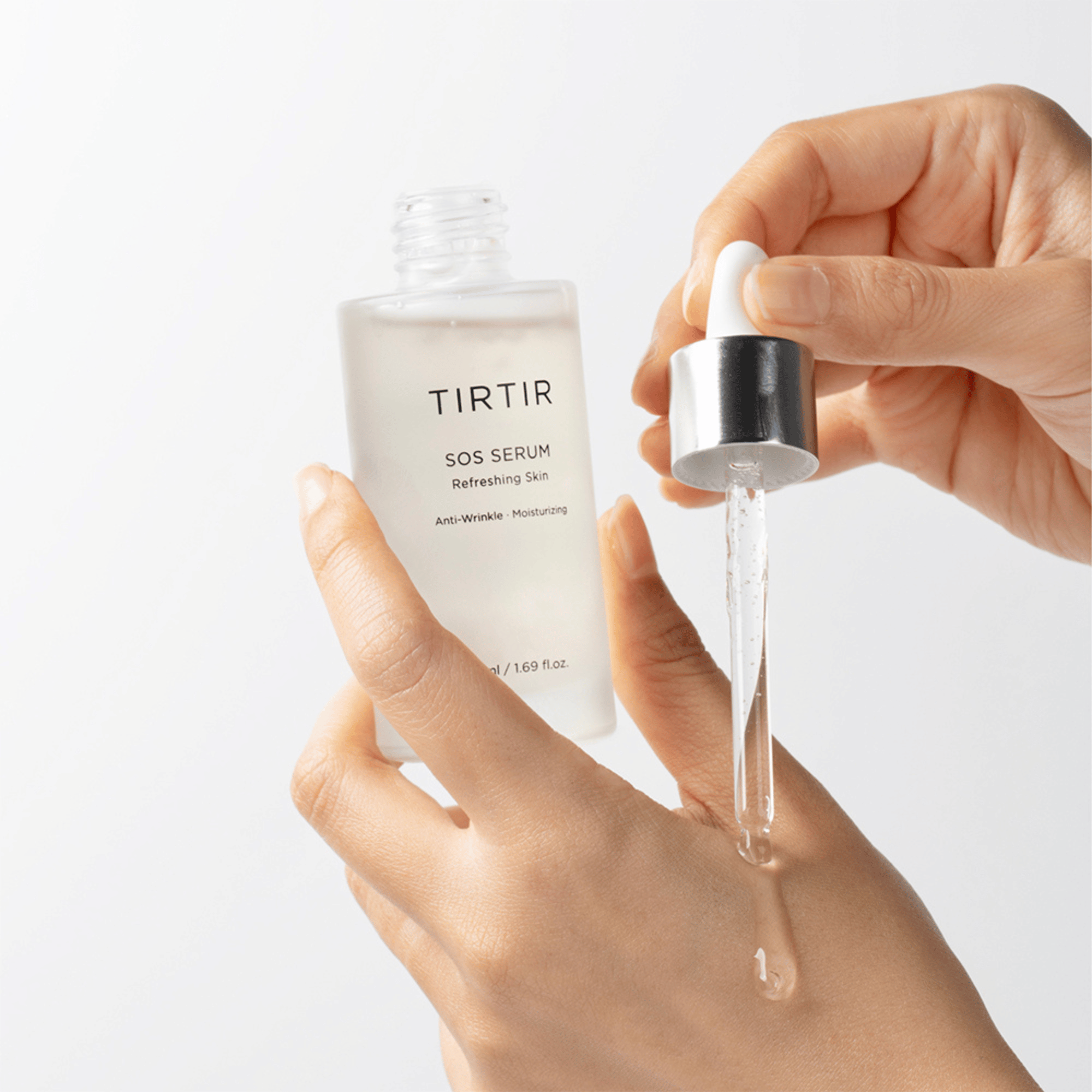 Hand trägt das durchsichtige TIRTIR SOS Serum mit Pipette auf feuchtigkeitsspendendes K-Beauty Produkt im Einsatz 