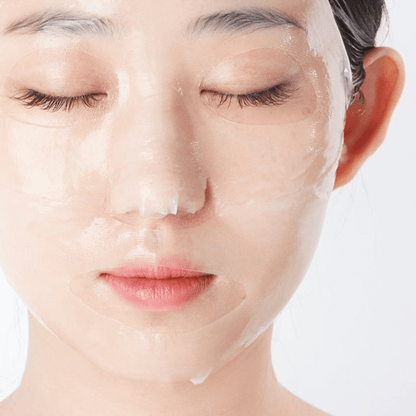 Nahaufnahme einer Person mit geschlossenen Augen, die eine Dr. Jart+ Vital Hydra Solution Mask trägt, vor einem schlichten weißen Hintergrund.