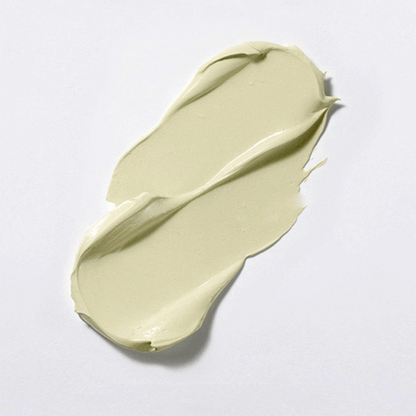 Die Textur des Cicapair Tiger Grass Color Correcting Treatment eine hellgrüne Creme, wird auf eine weiße Oberfläche aufgetragen.