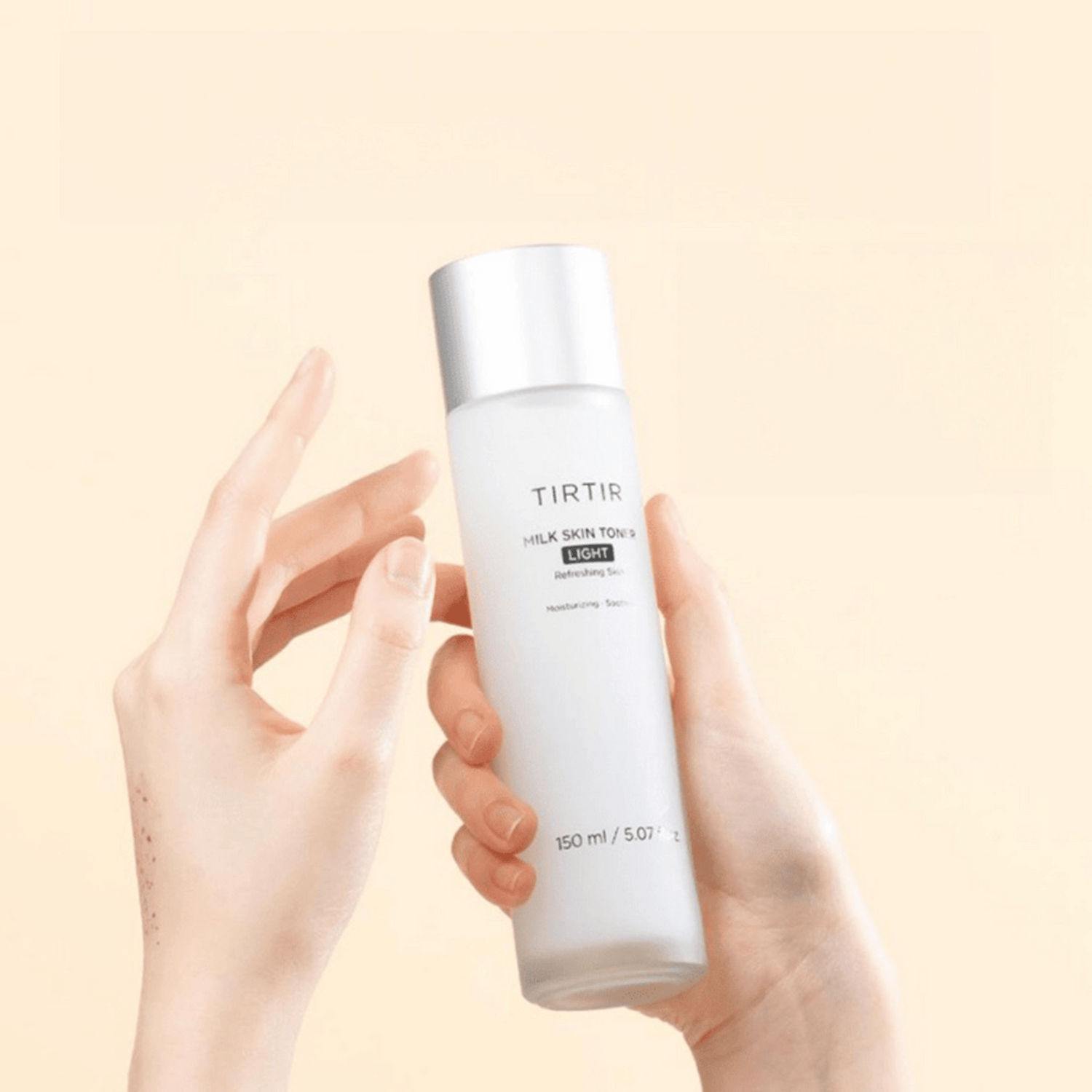Zwei Hände halten die minimalistische Flasche des TIRTIR Milk Skin Toner Light 150ml vor pastellfarbenem Hintergrund