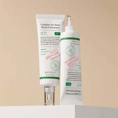 Zwei Tuben der AXIS-Y Complete No-Stress Physical Sunscreen nebeneinander auf einem hellen Block mit cremigem, natürlichem Licht