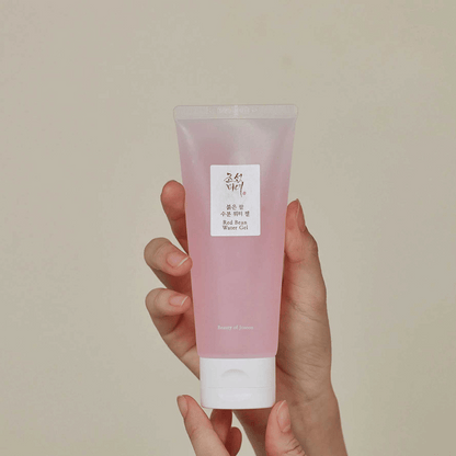Beauty of Joseon Red Bean Water Gel mit rosa Geltextur in transparenter Tube, fest in der Hand gehalten