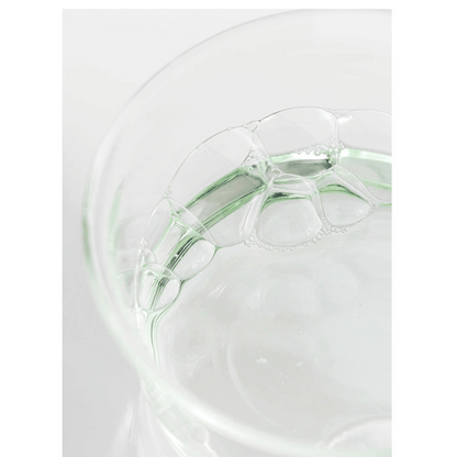 Klare, grünliche Flüssigkeit mit Schaumblasen in einer Glas-Petrischale – Textur des Toners von Beauty of Joseon